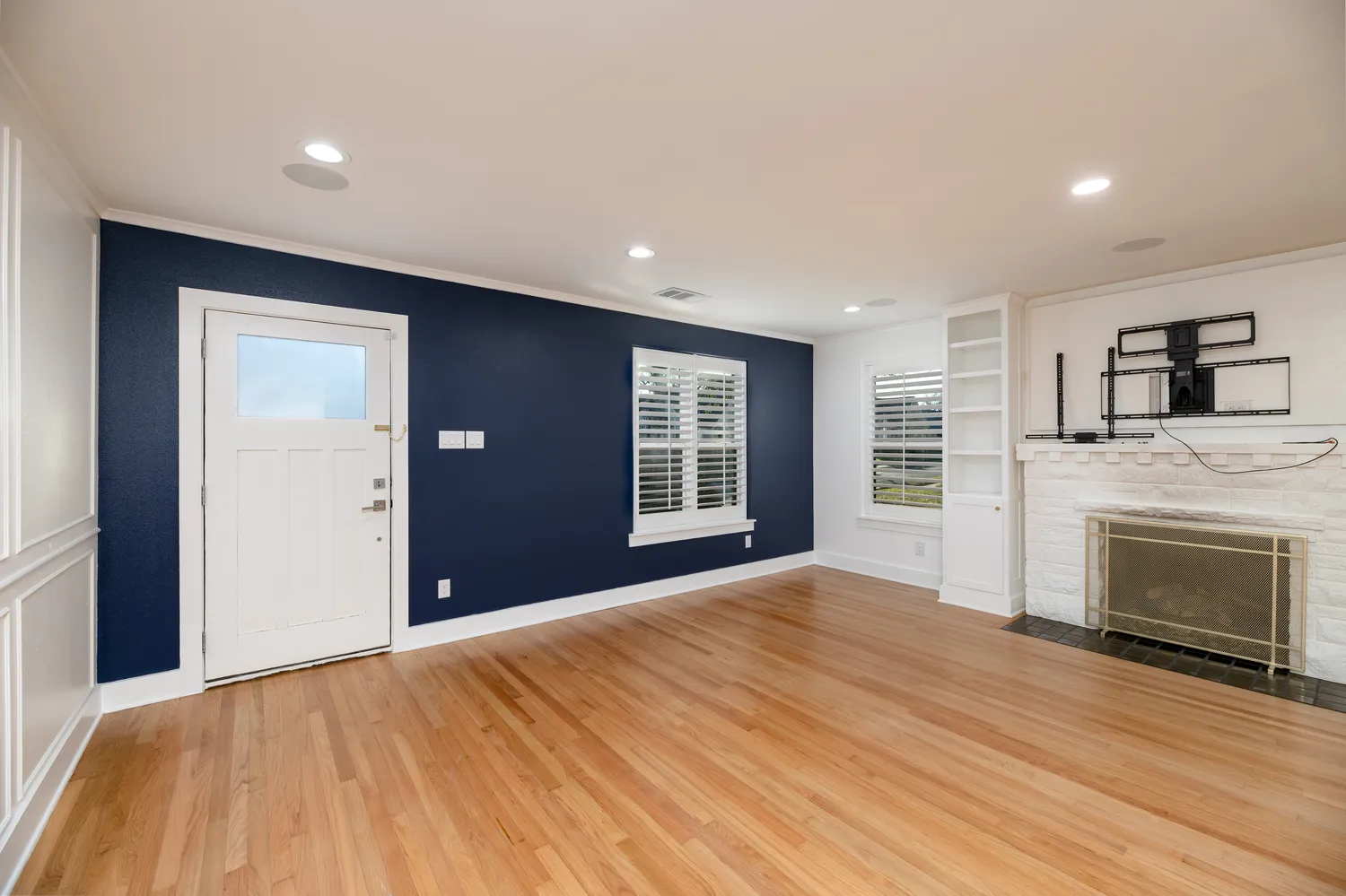 a view of empty room with wooden floor and fireplace