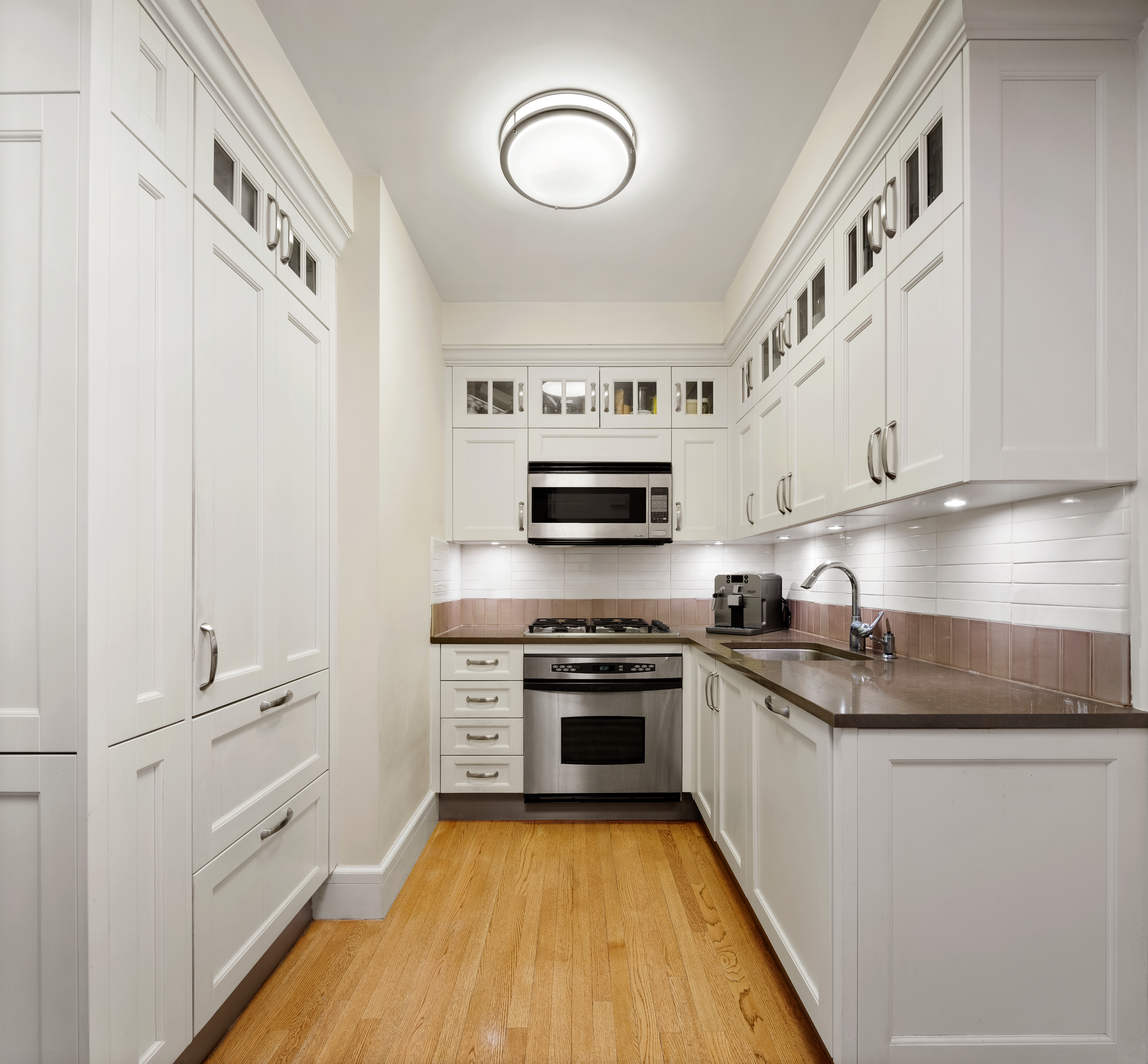 27 West 72nd Street, Unit 1403 Manhattan, NY 10023 - Photo 8 of 16 a kitchen with granite countertop a sink cabinets stainless steel appliances and a counter space