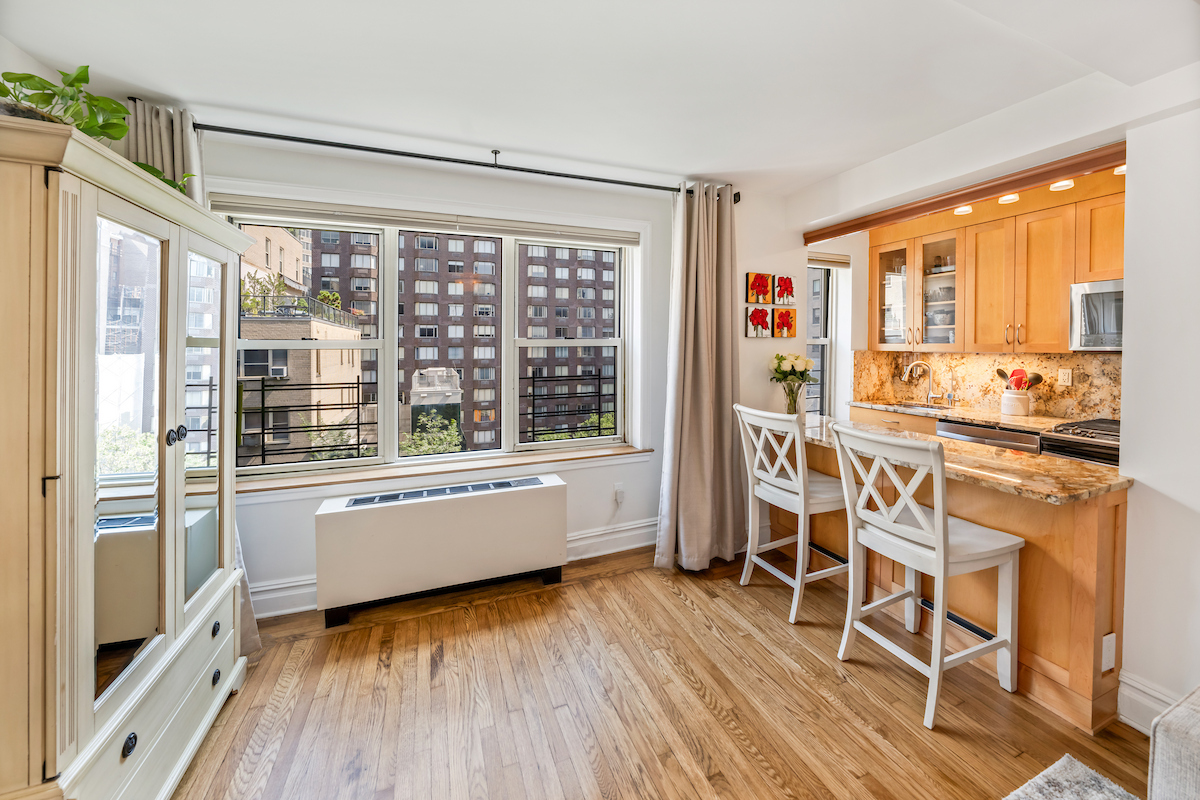 424 East 52nd Street, Unit 9B Manhattan, NY 10022 - Photo 2 of 9 a large white kitchen with granite countertop a large window and white appliances