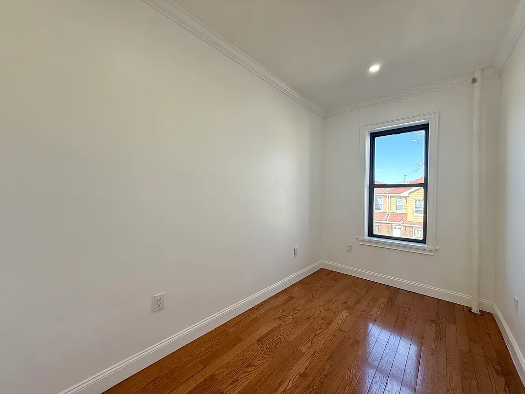 82 74th Street Brooklyn, NY 11209 - Photo 18 of 21 an empty room with wooden floor and windows