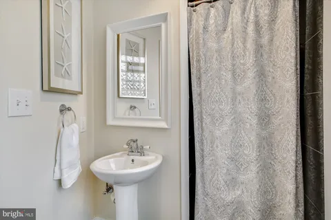 a bathroom with a sink a mirror and a shower curtain