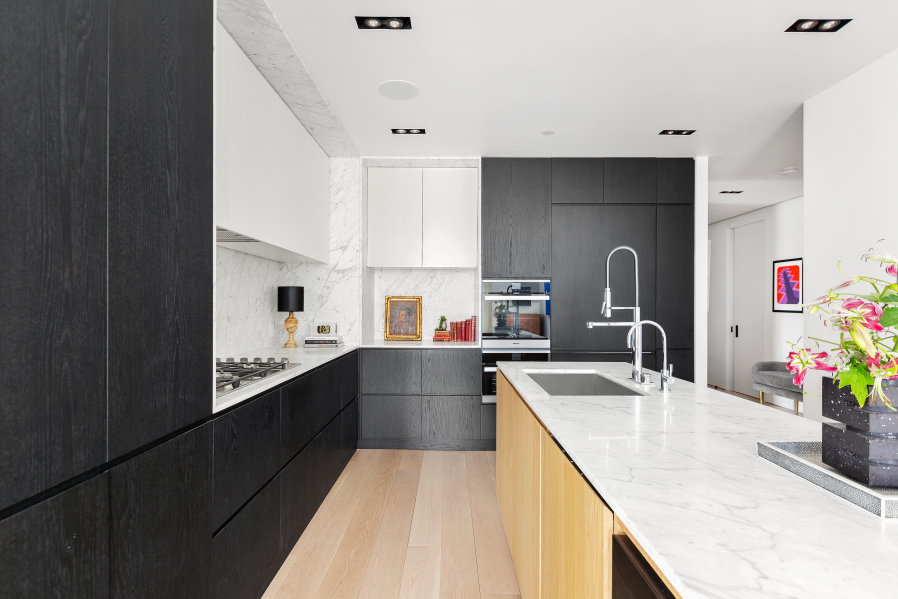 177 9th Avenue, Unit 5H Manhattan, NY 10011 - Photo 5 of 20 a kitchen with granite countertop a sink stainless steel appliances wooden floor and cabinets