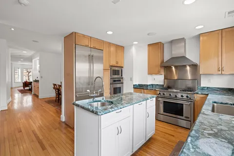 a kitchen with stainless steel appliances granite countertop a stove refrigerator and a sink