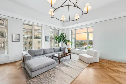a living room with furniture a chandelier and a large window