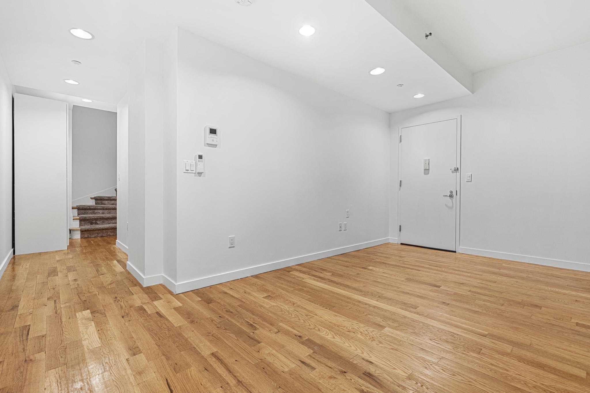 306 West 116th Street, Unit 1C Manhattan, NY 10026 - Photo 10 of 12 a view of an empty room with wooden floor