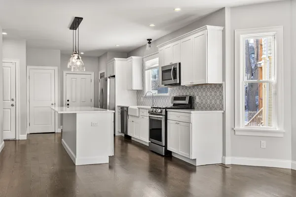 a kitchen with white cabinets and stainless steel appliances