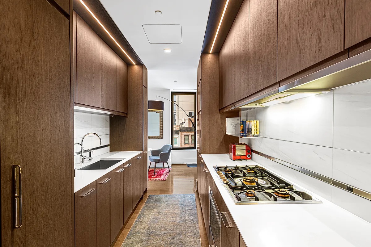 301 East 50th Street, Unit 4B Manhattan, NY 10022 - Photo 5 of 13 a kitchen with stainless steel appliances granite countertop a sink stove and refrigerator