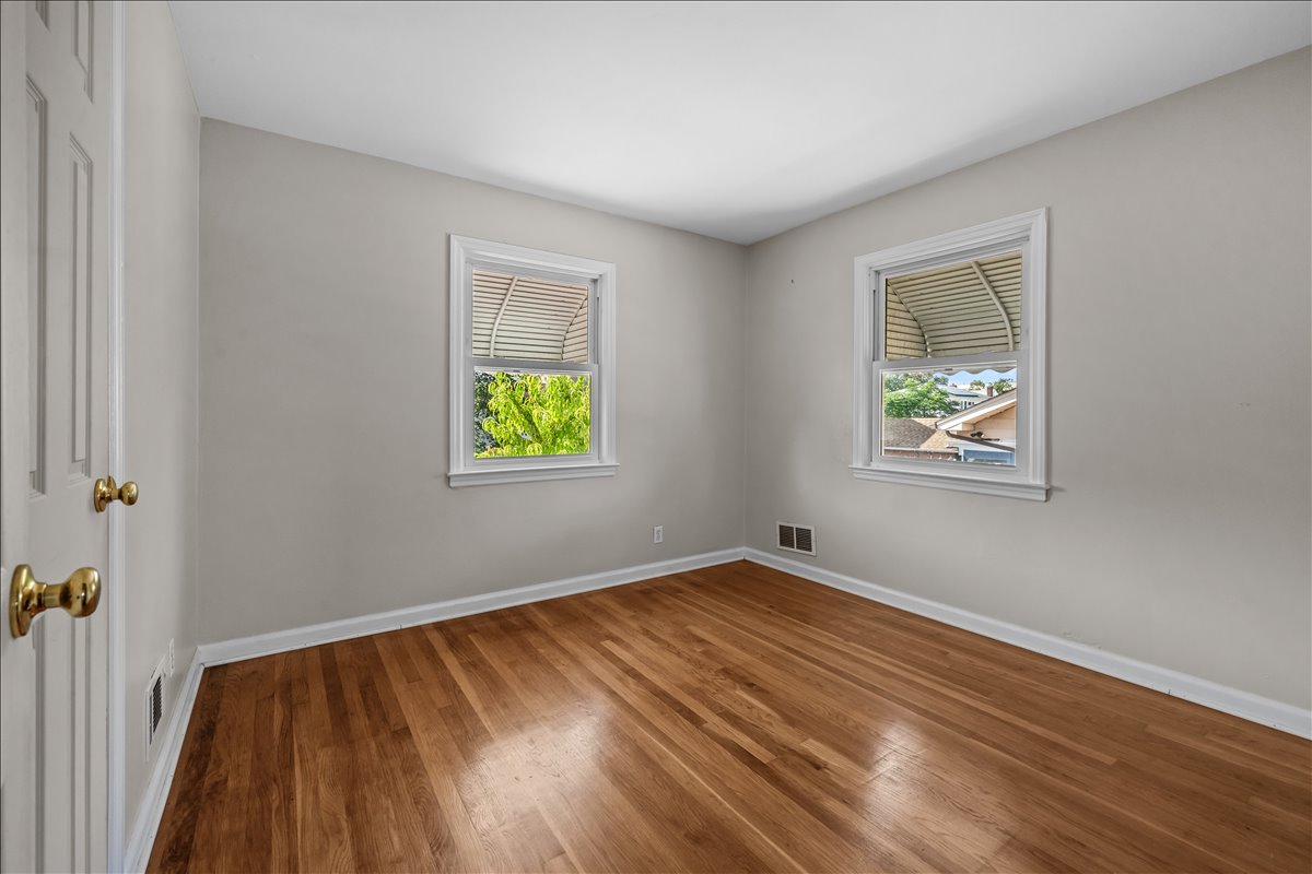 100-14 159th Avenue Queens, NY 11414 - Photo 14 of 26 a view of an empty room with window and wooden floor