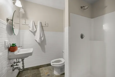 a bathroom with a sink a toilet and a shower