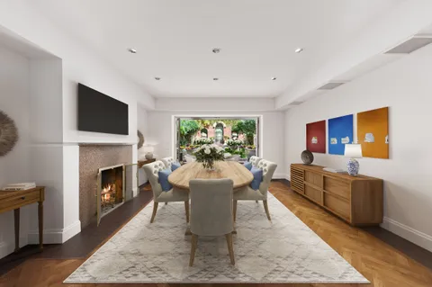 a living room with furniture a rug a fireplace and a window