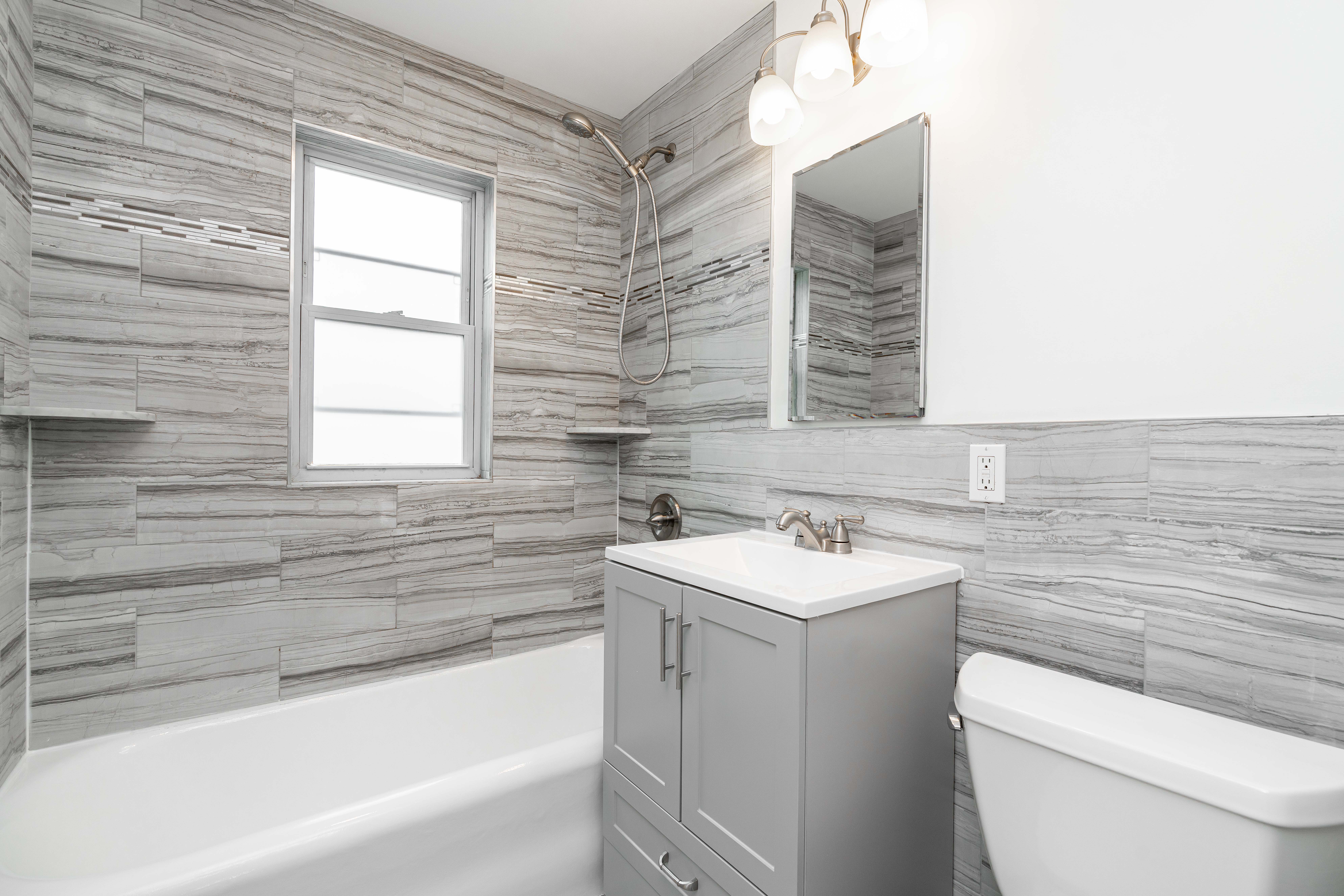 20-60 33rd Street, Unit 2 Queens, NY 11105 - Photo 6 of 10 a bathroom with a sink toilet vanity and bathtub