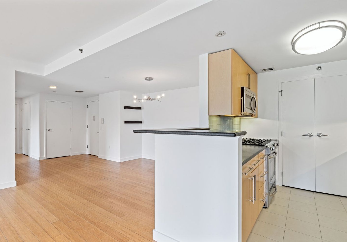 40 West 116th Street, Unit B503 Manhattan, NY 10026 - Photo 5 of 36 a kitchen with stainless steel appliances granite countertop a refrigerator and a stove top oven