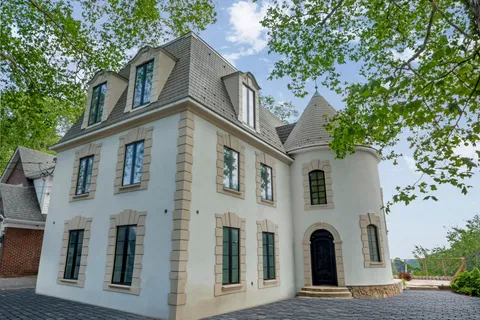a front view of a house with a tree