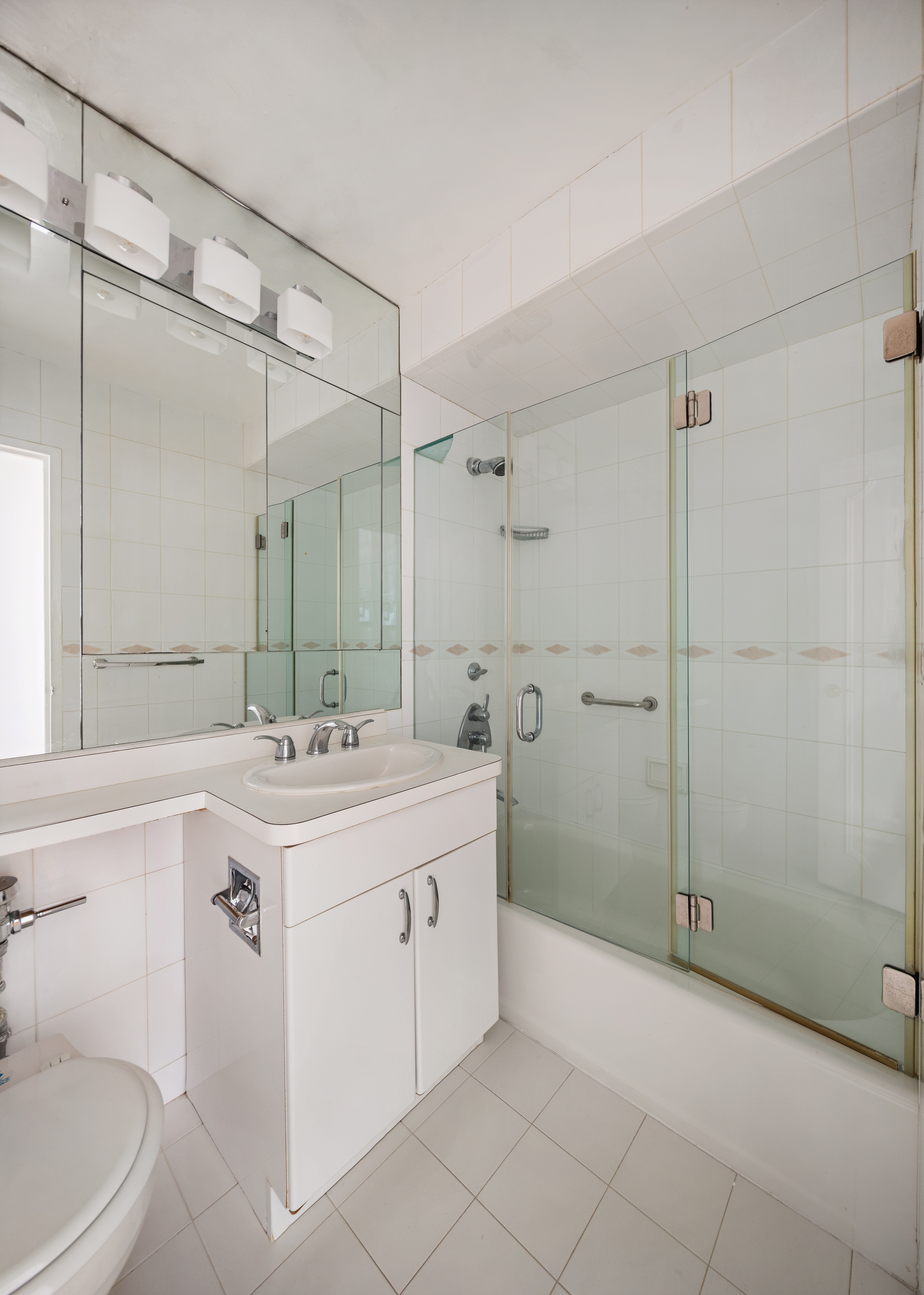 201 East 66th Street, Unit 2E Manhattan, NY 10065 - Photo 12 of 15 a bathroom with a sink double vanity and a shower