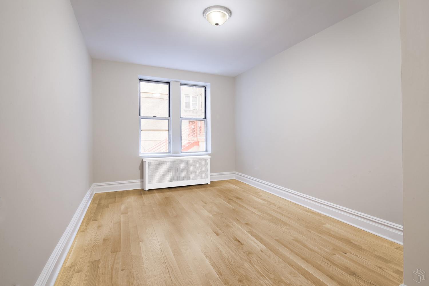 156-08 Riverside Drive West, Unit 1K Manhattan, NY 10032 - Photo 4 of 7 an empty room with wooden floor and windows