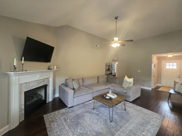a living room with furniture a fireplace and a flat screen tv