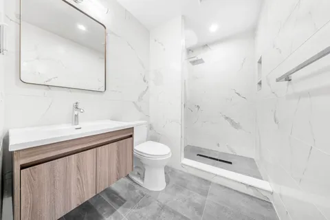 a bathroom with a sink a toilet and shower