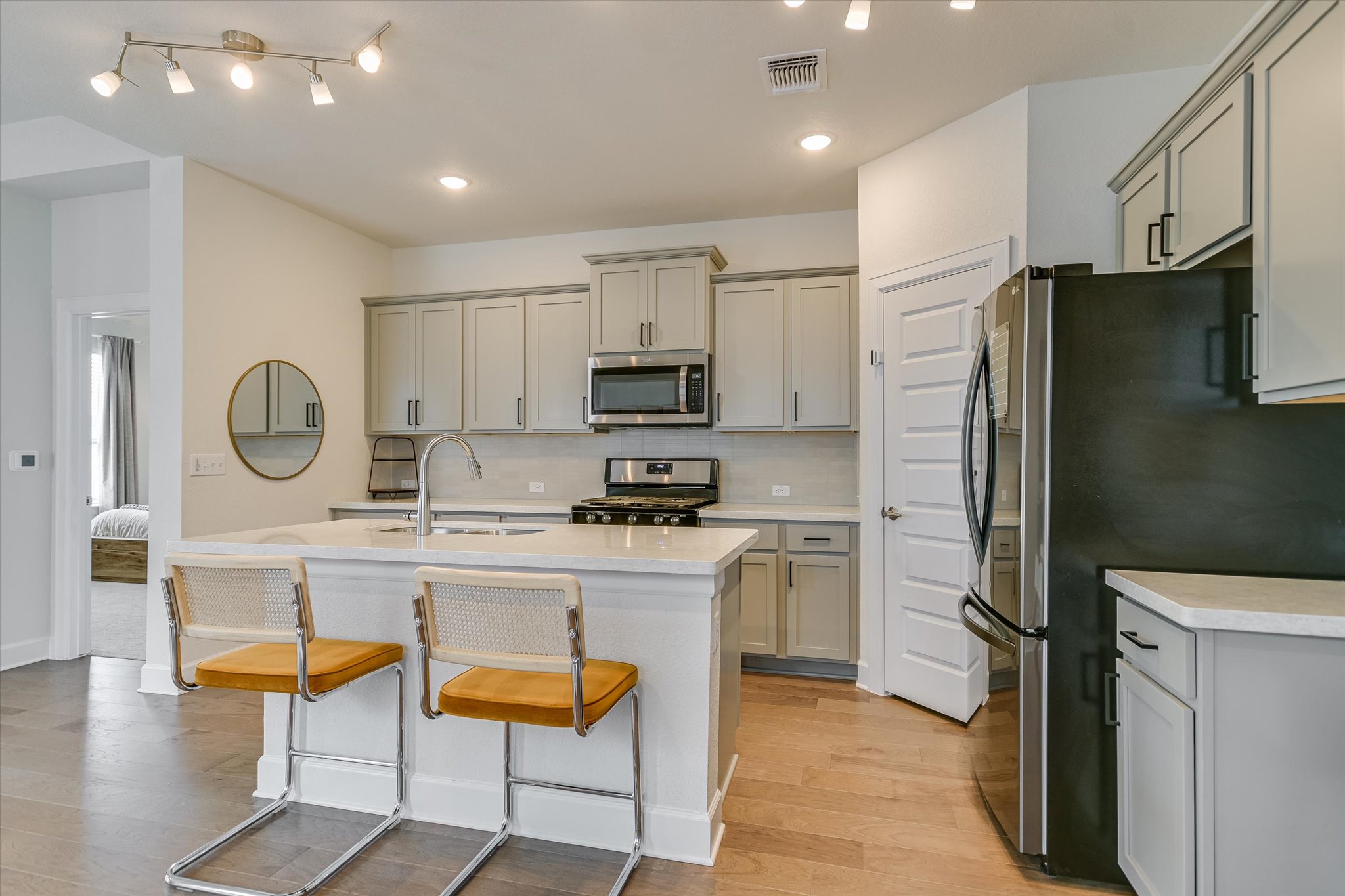 8607 McKamy Drive Austin, TX 78744 - Photo 6 of 28 a kitchen with stainless steel appliances granite countertop a refrigerator a stove microwave and cabinets