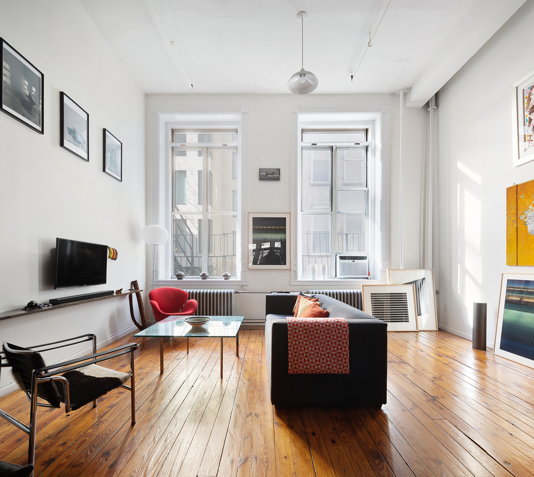 135 Greene Street, Unit 2N Manhattan, NY 10012 - Photo 6 of 13 a living room with furniture and a flat screen tv