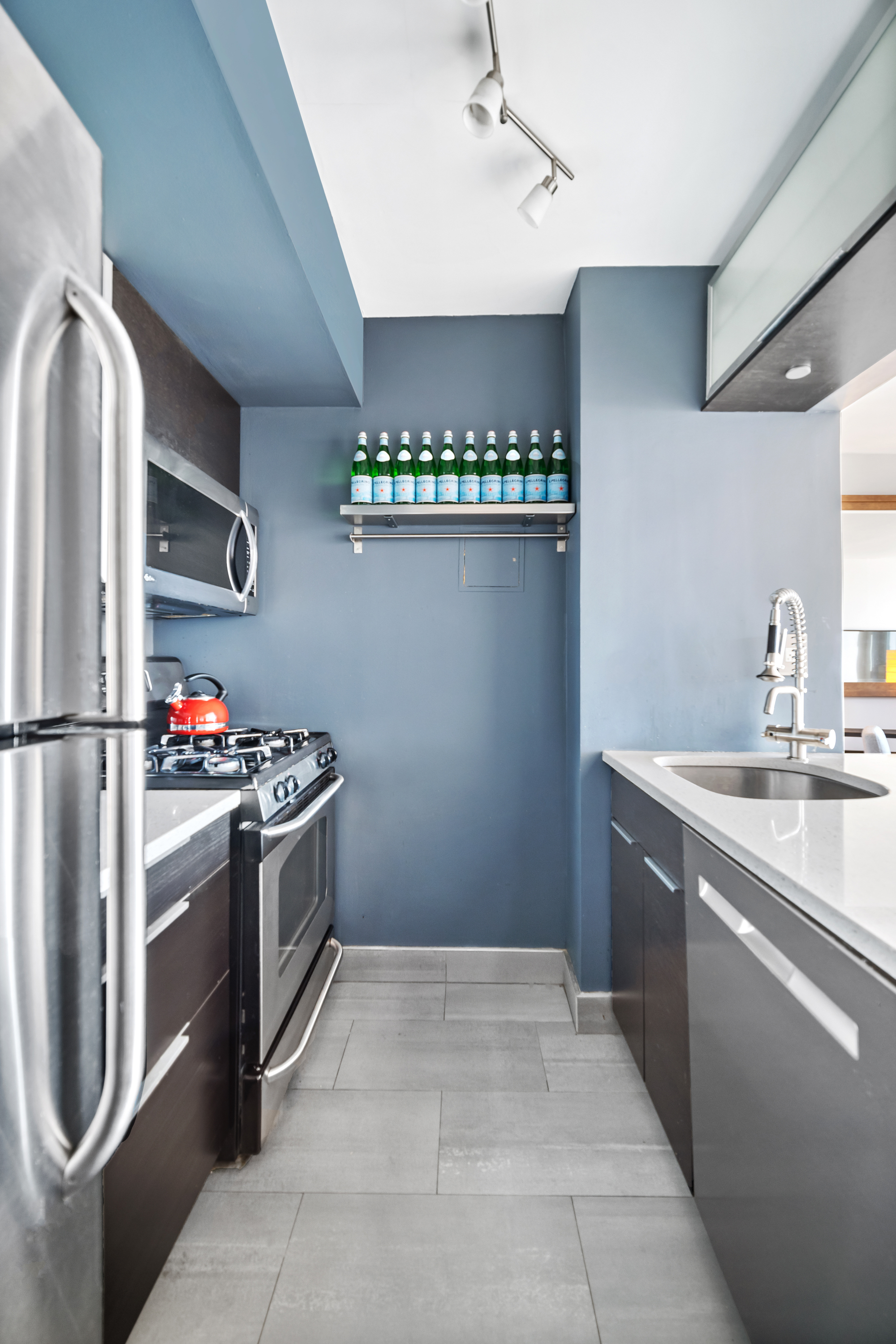 1 Irving Place, Unit U21E Manhattan, NY 10003 - Photo 5 of 9 a kitchen with granite countertop a refrigerator and a stove top oven