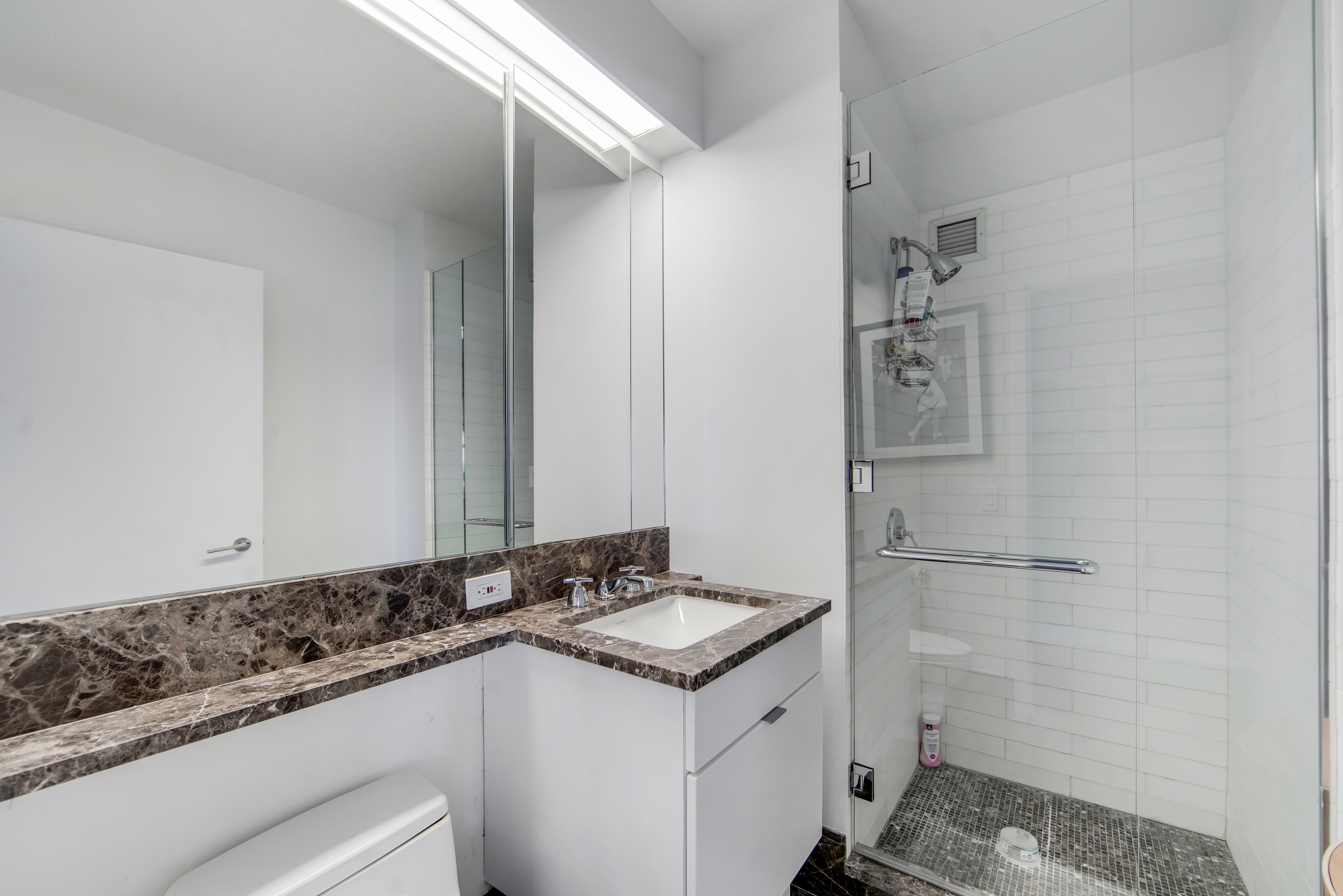 207 East 57th Street, Unit 20A Manhattan, NY 10022 - Photo 14 of 18 a bathroom with a sink and a mirror