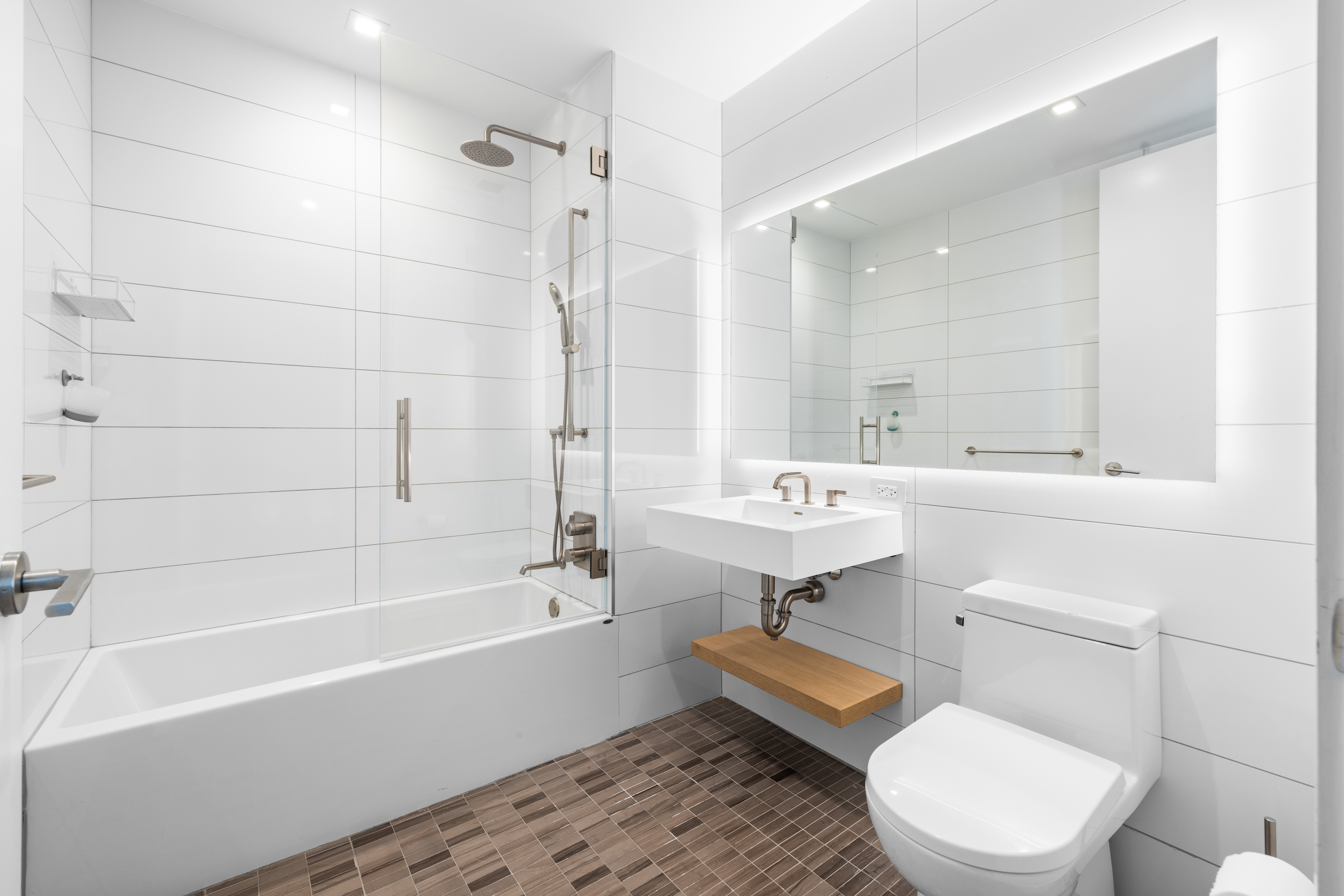 98 Front Street, Unit PH Brooklyn, NY 11201 - Photo 12 of 26 a bathroom with a sink a toilet a mirror and a bathtub