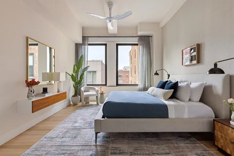 a bedroom with a large bed and windows