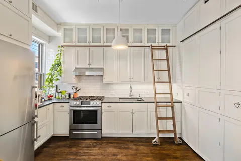 a kitchen with white cabinets and white appliances