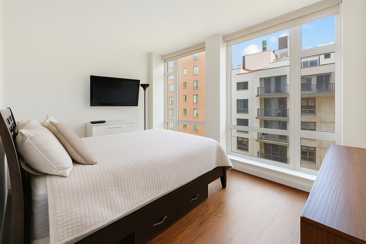 133 West 22nd Street, Unit 6L Manhattan, NY 10011 - Photo 4 of 11 a bedroom with a bed and a flat tv screen on wall