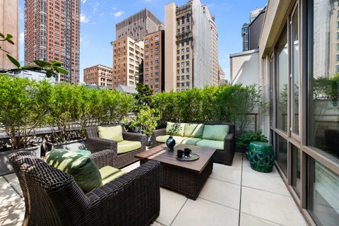 a view of a patio with couches table and chairs and potted plants