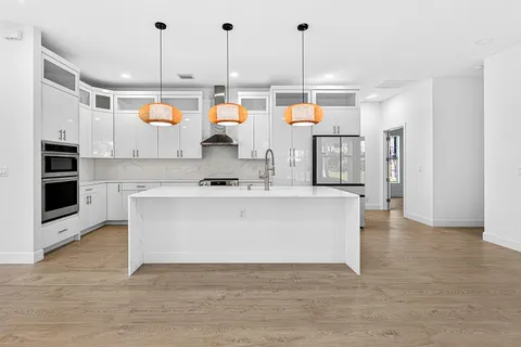 a view living room with stainless steel appliances kitchen island wooden floor and living room view