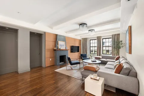 a living room with fireplace furniture and a large window
