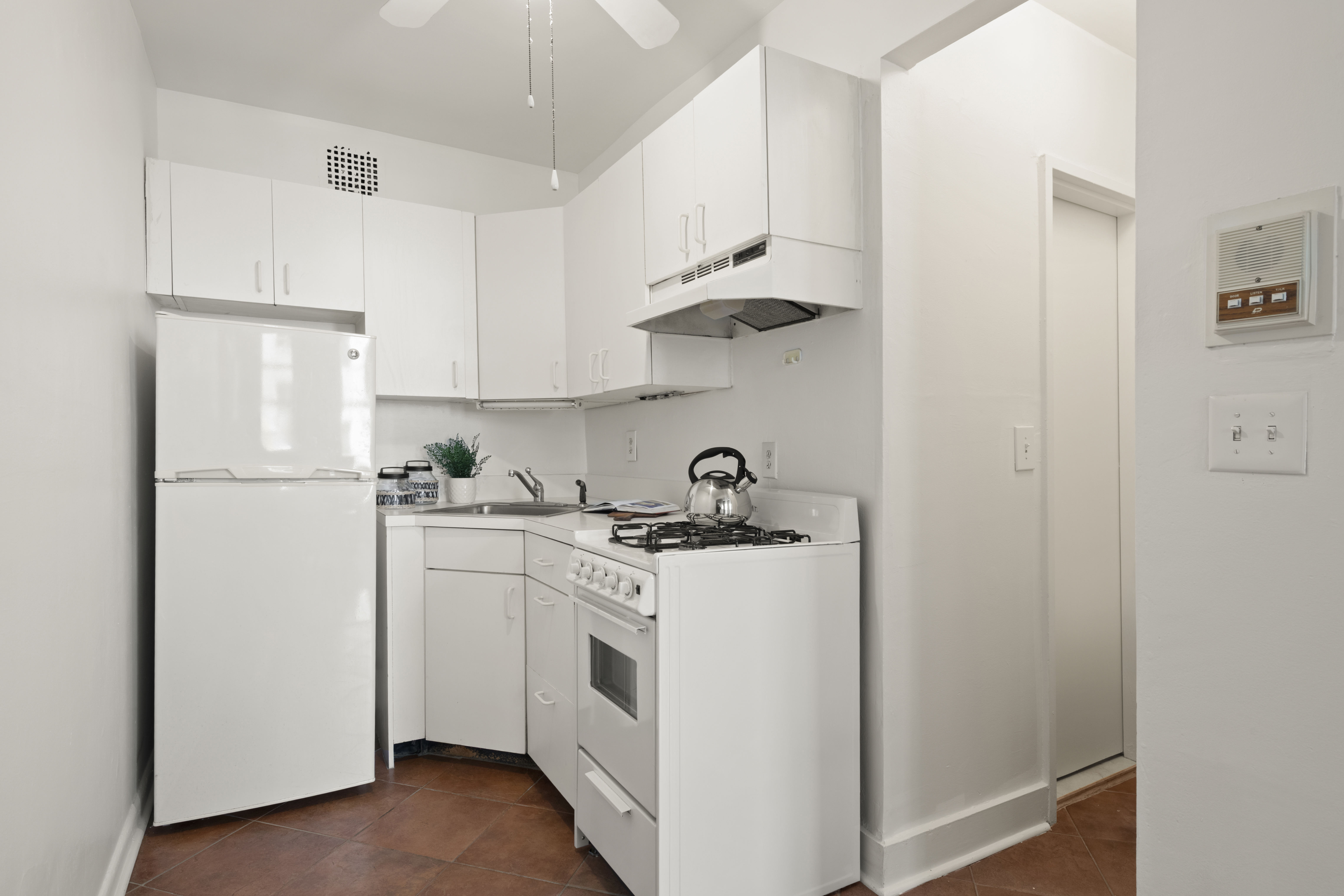 132 West 71st Street, Unit 3 Manhattan, NY 10023 - Photo 4 of 7 a kitchen with a white stove refrigerator and white cabinets with wooden floor