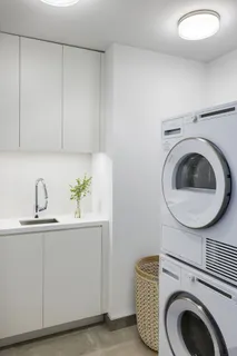 a utility room with sink dryer and washer