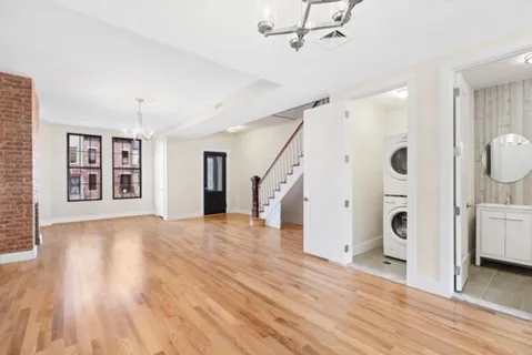 a view of a livingroom with wooden floor and staircase