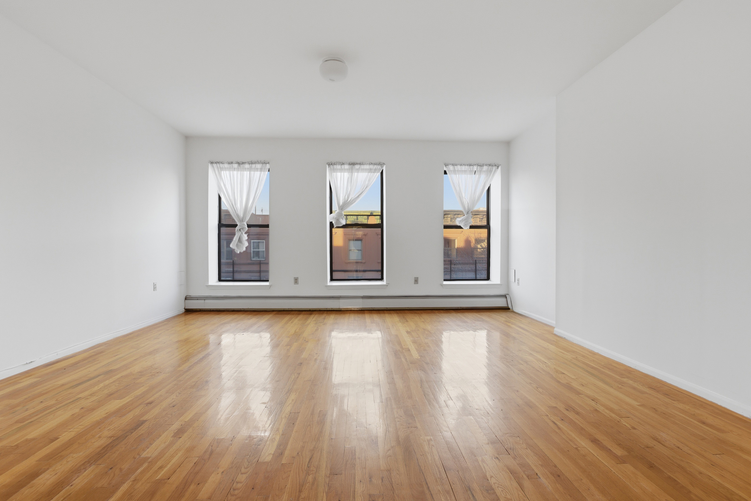 20 East 126th Street Manhattan, NY 10035 - Photo 13 of 19 an empty room with wooden floor and windows