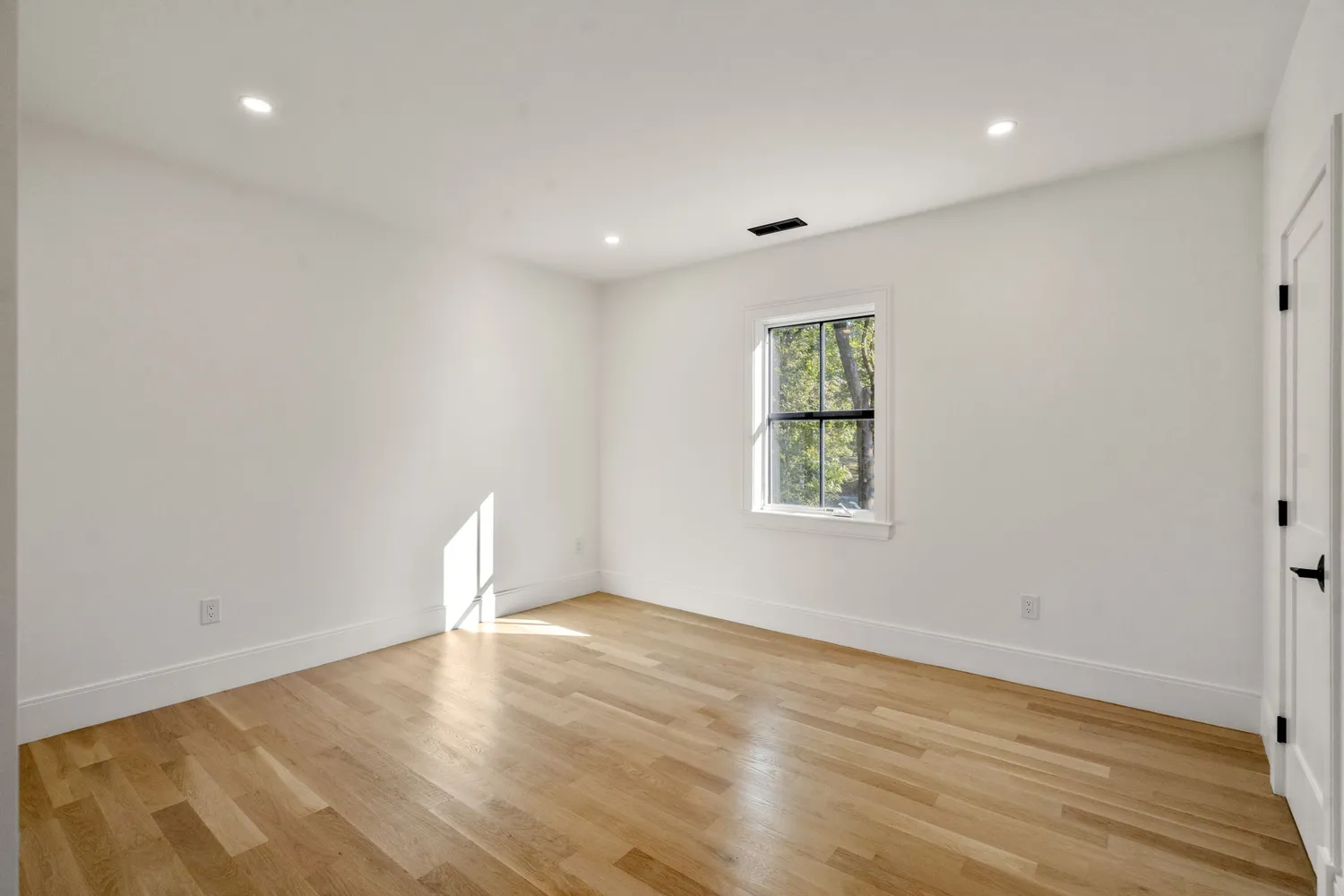 wooden floor in an empty room with a window