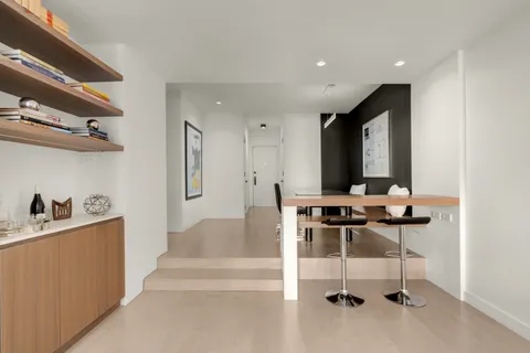 a view of hall way with furniture and chandelier