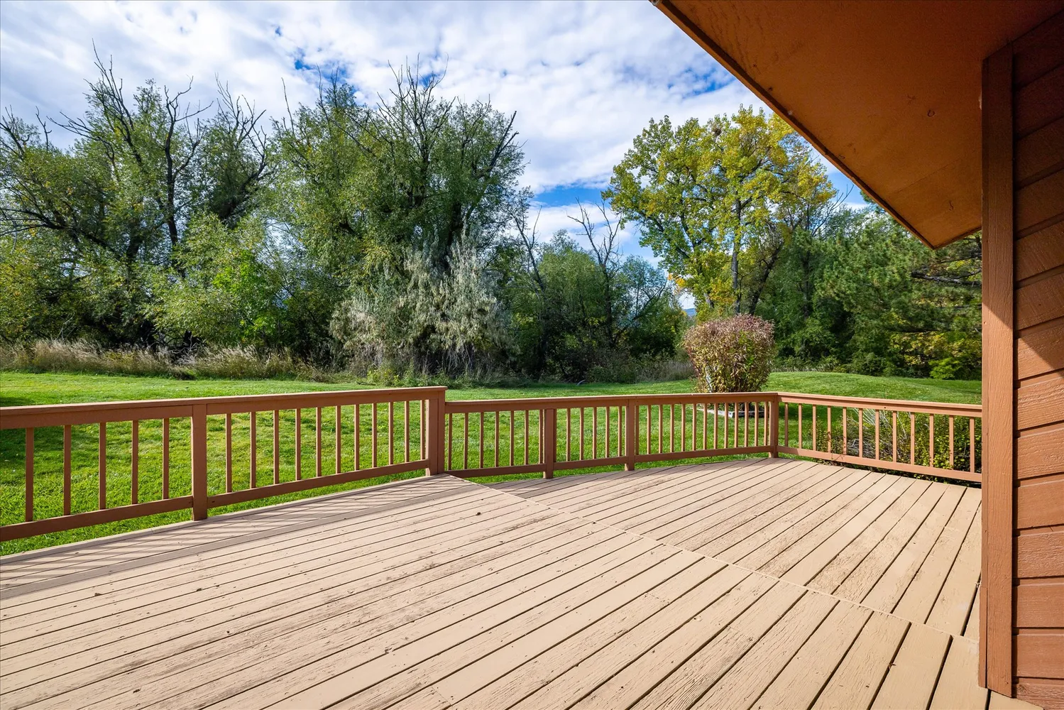 a view of balcony with wooden floor and fence