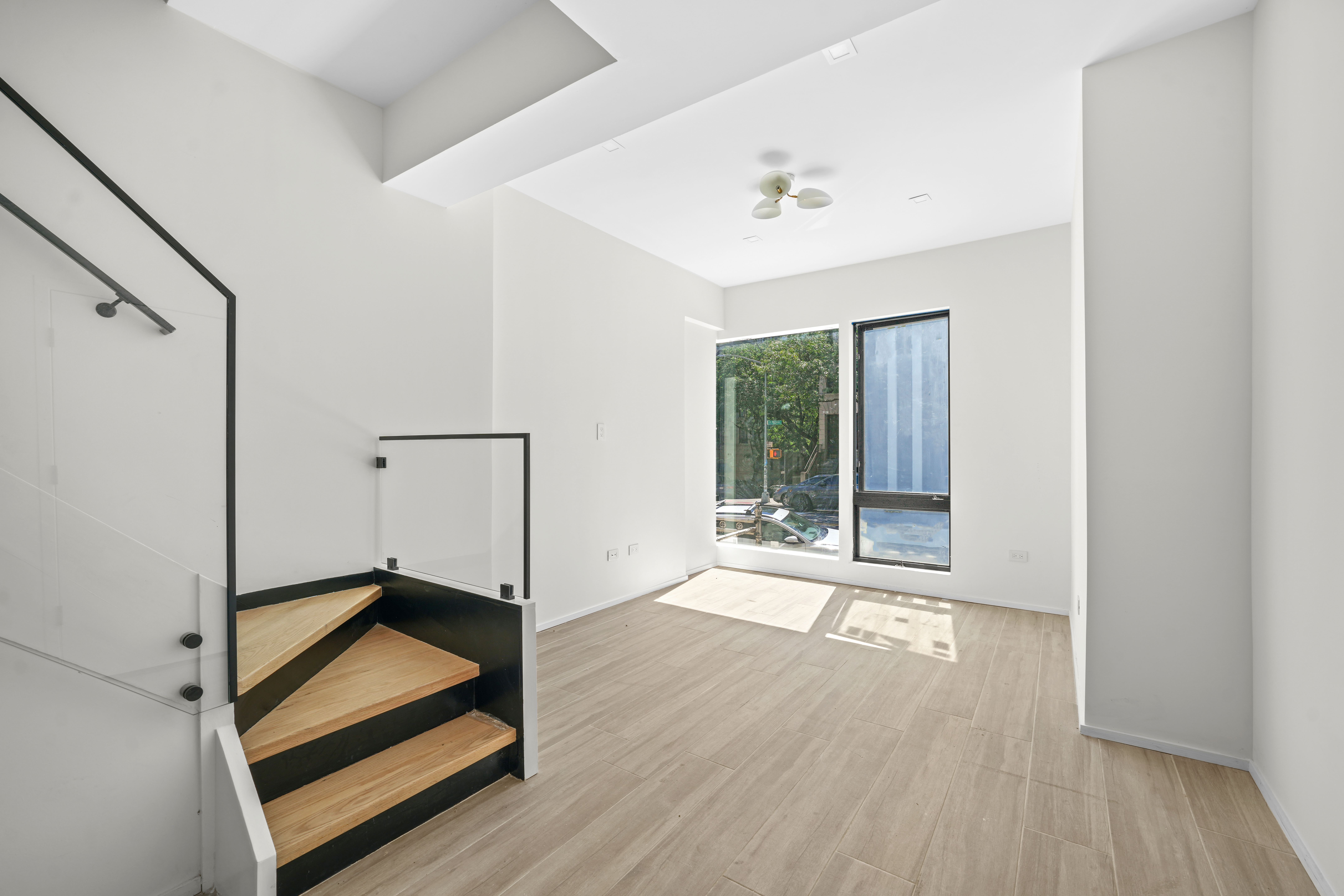 953 St Nicholas Avenue, Unit 1 Manhattan, NY 10032 - Photo 3 of 15 a view of an empty room with wooden floor and a window