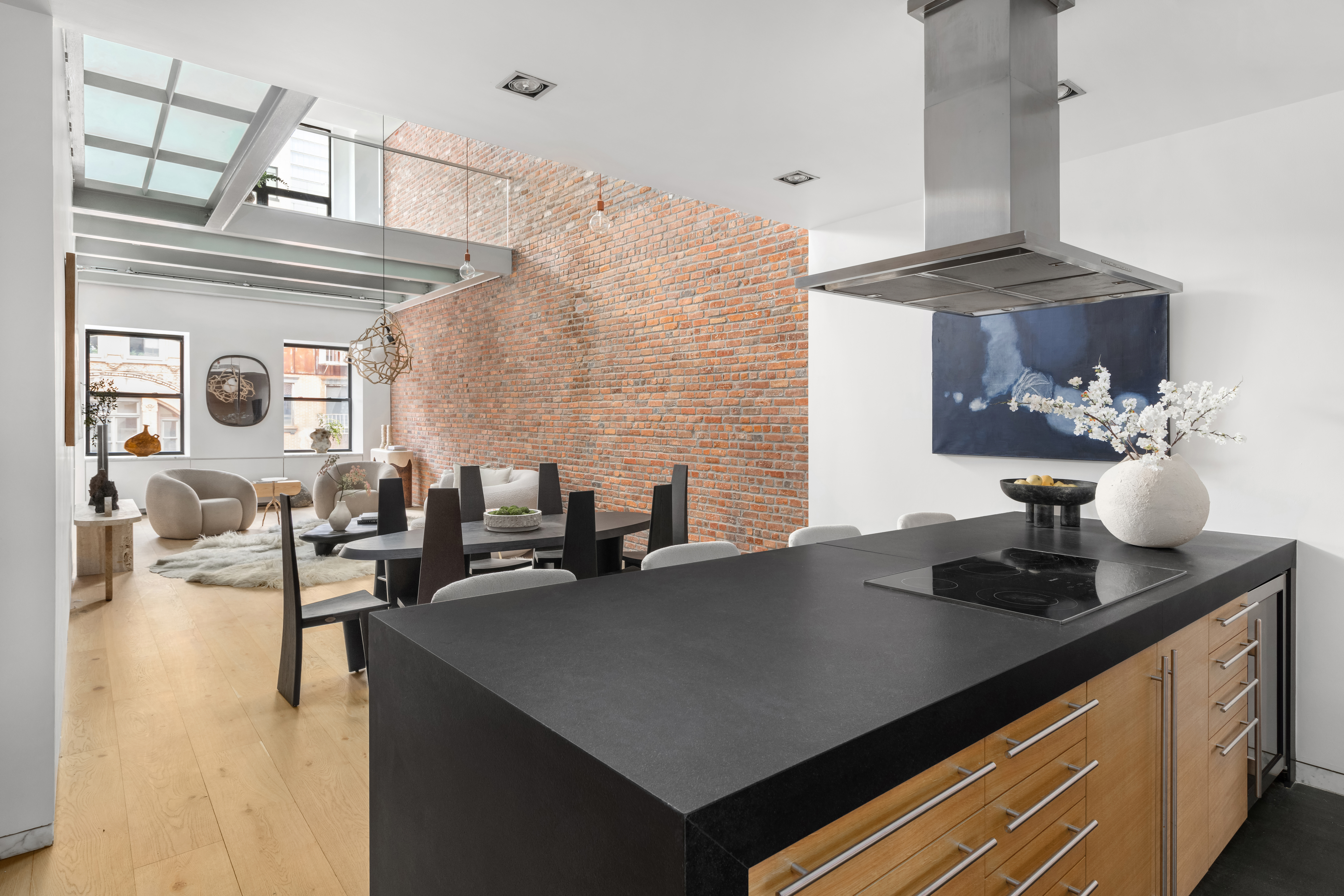 74 Warren Street, Unit 5W Manhattan, NY 10007 - Photo 6 of 15 a kitchen with a sink dishwasher a stove and a dining table with wooden floor