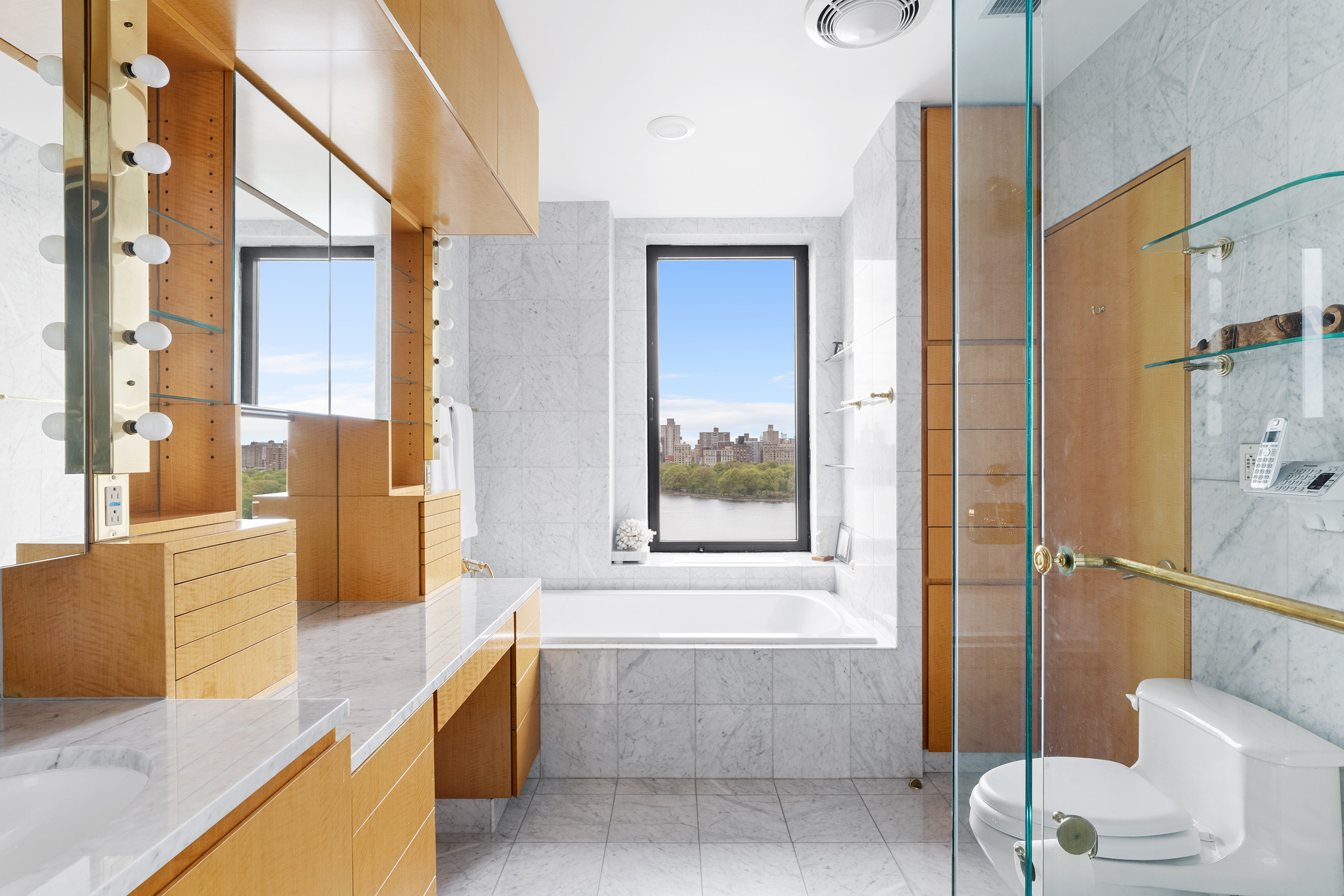 1115 5th Avenue, Unit 15A Manhattan, NY 10128 - Photo 20 of 27 a bathroom with a tub a sink and glass door