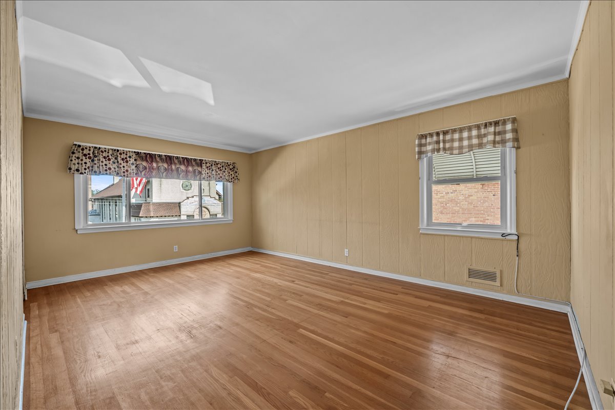 100-14 159th Avenue Queens, NY 11414 - Photo 12 of 26 a view of an empty room with wooden floor and a window