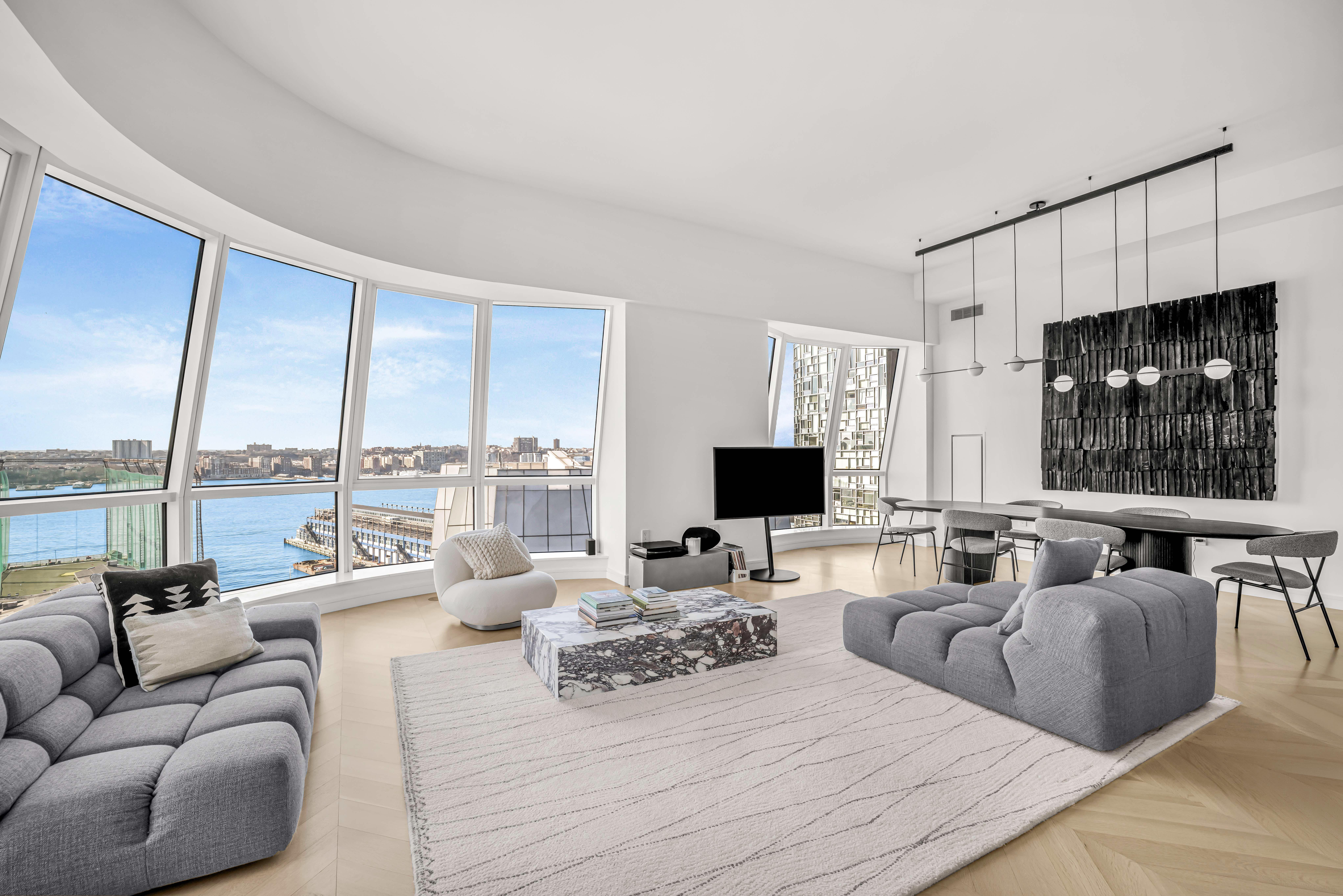 a living room with furniture a flat screen tv and a large window