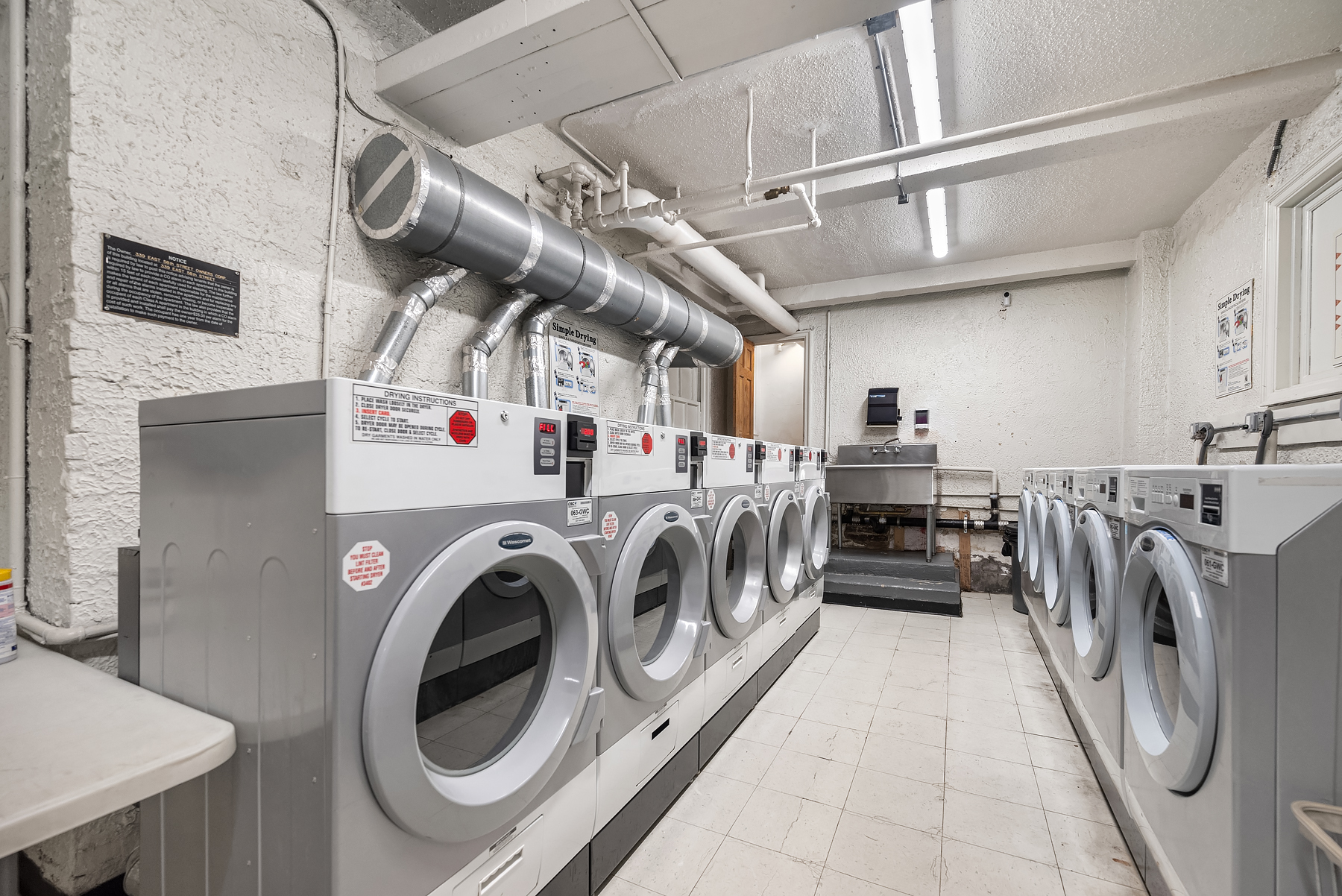 339 East 58th Street, Unit 3J Manhattan, NY 10022 - Photo 6 of 9 a utility room with dryer and washer