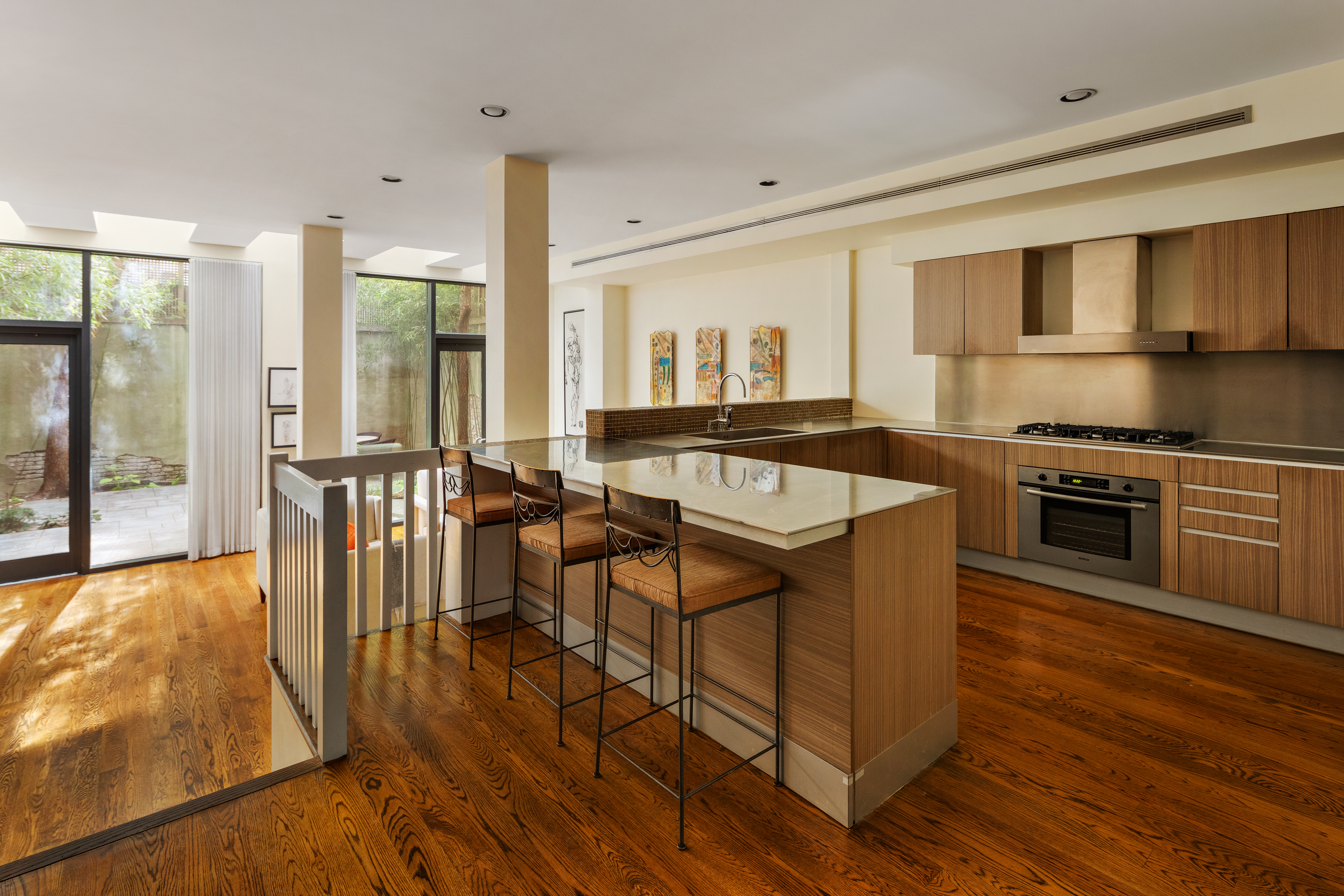 181 Sullivan Street, Unit GARDEN Manhattan, NY 10012 - Photo 2 of 10 a kitchen with stainless steel appliances granite countertop a stove top oven a sink and a table with chairs