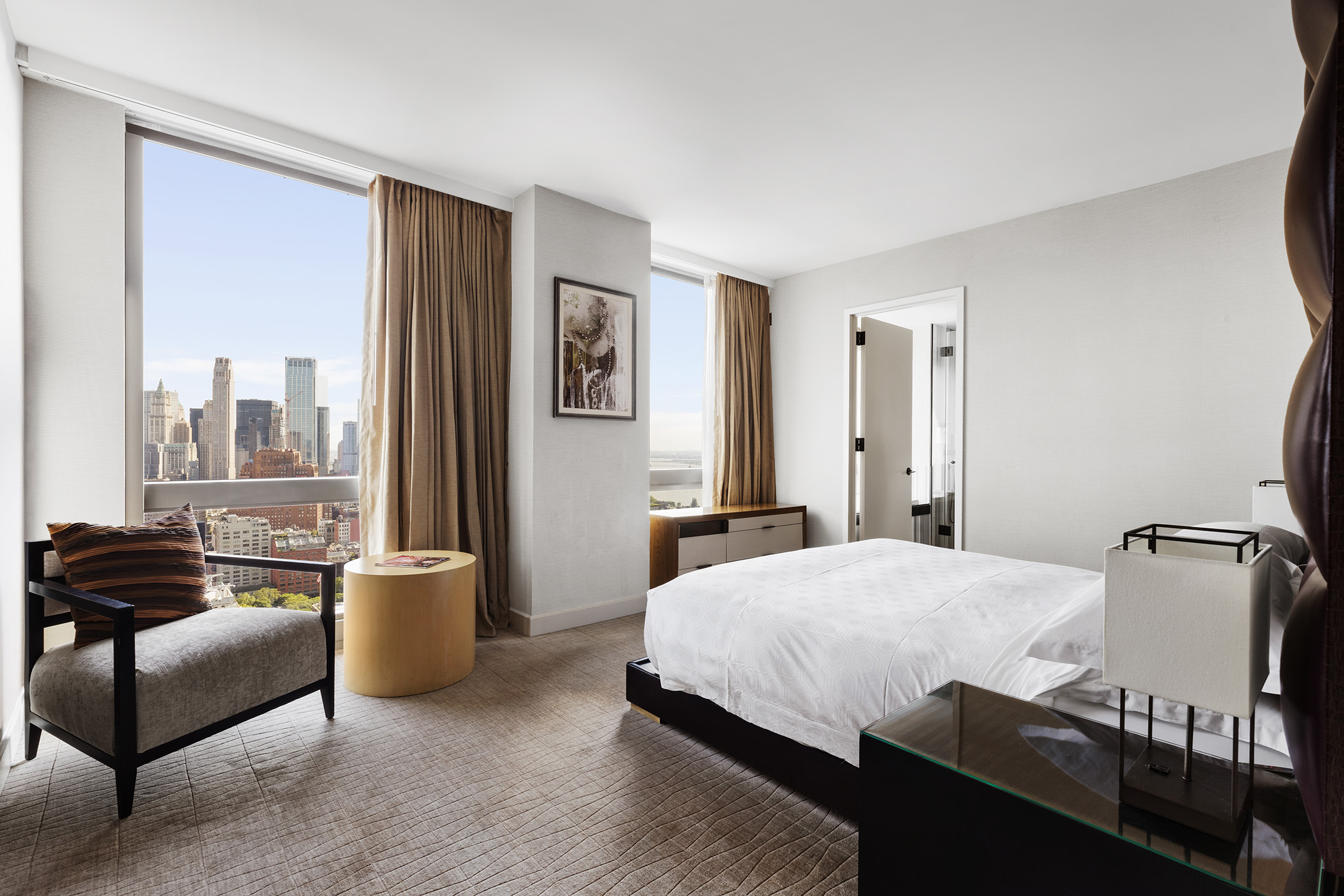 246 Spring Street, Unit 4104 Manhattan, NY 10013 - Photo 2 of 8 a bedroom with a bed and a couch