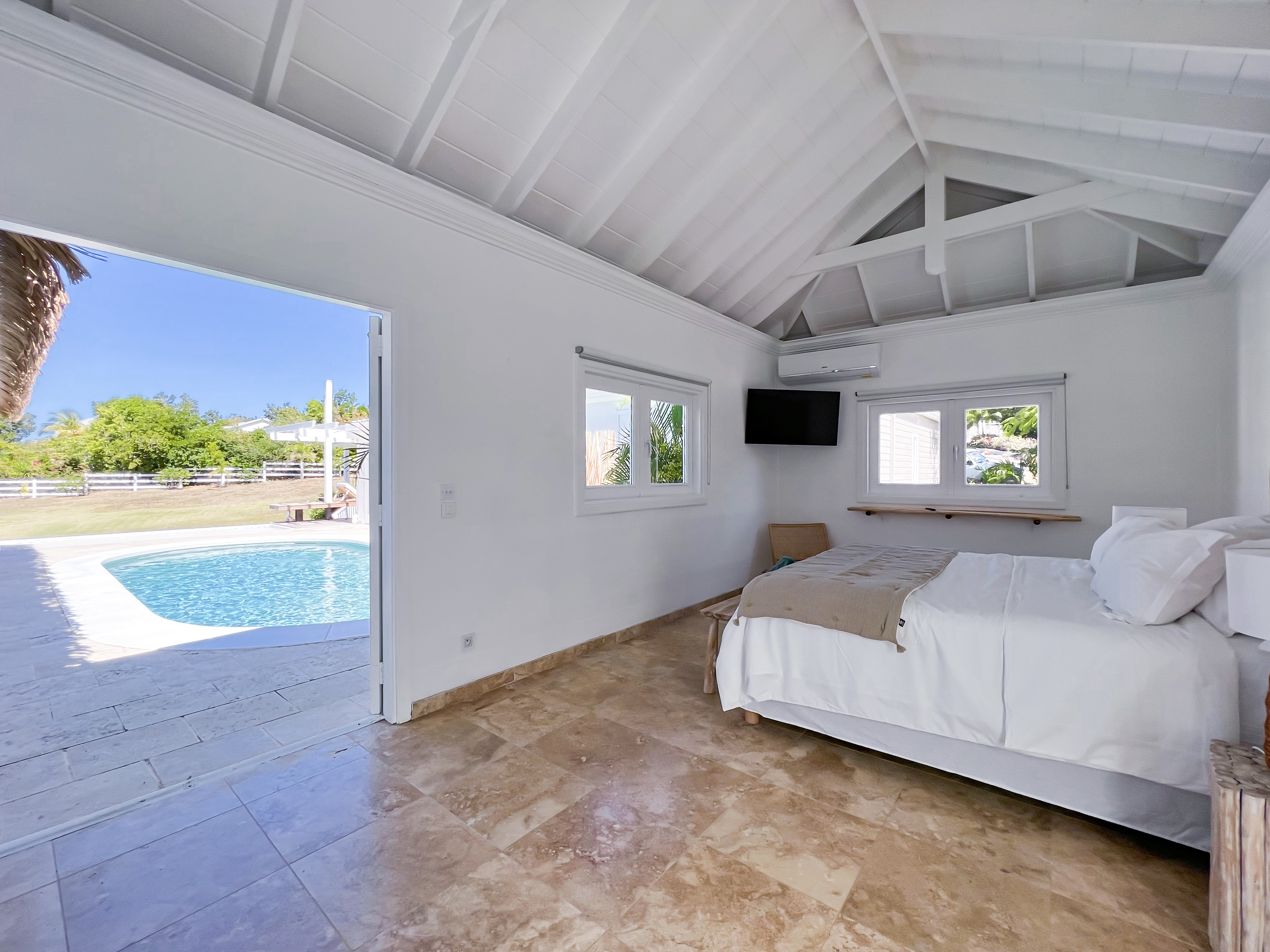 Terres Basses St. Martin, undefined 97150 - Photo 20 of 32 a bedroom with a bed and a night stand with lamp