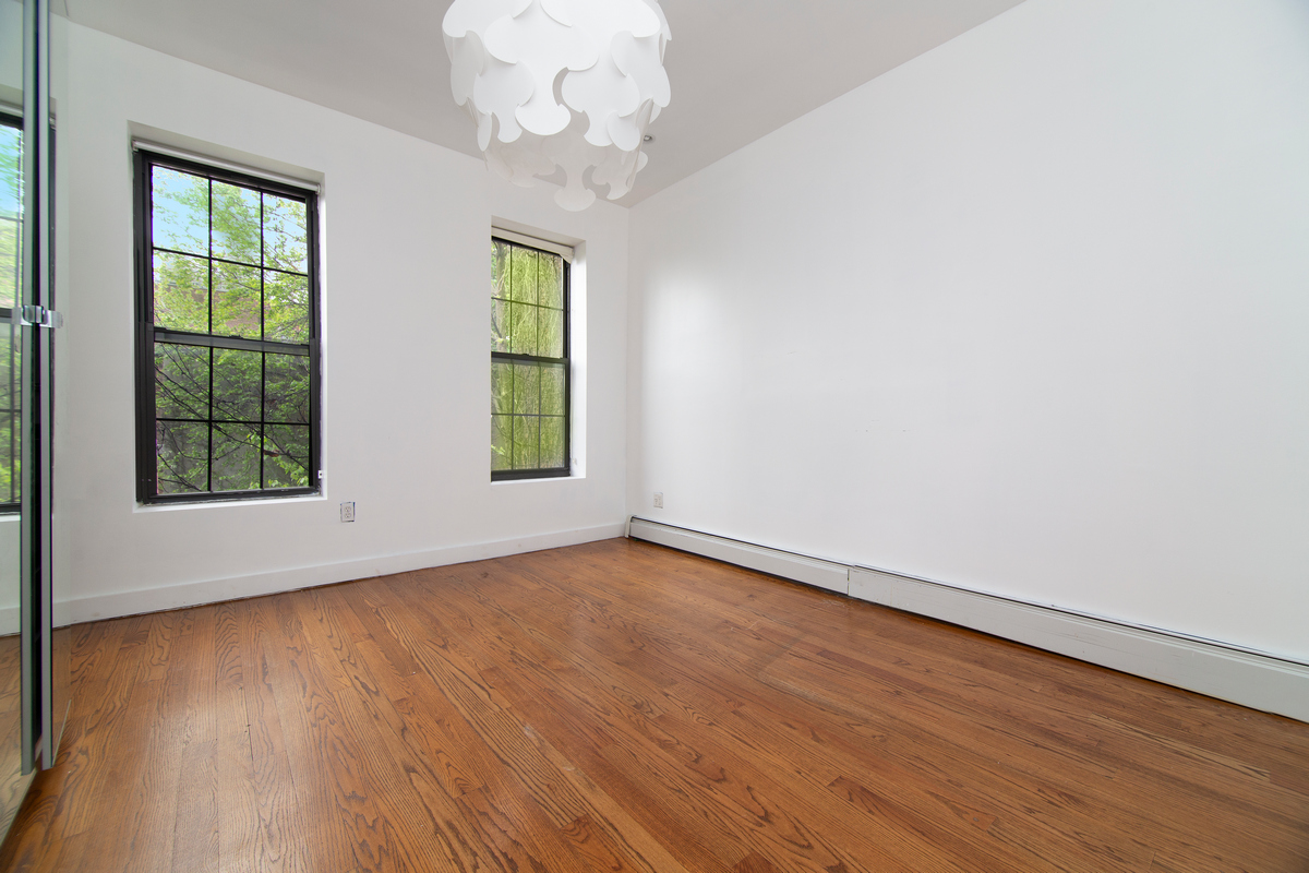 900 Lafayette Avenue Brooklyn, NY 11221 - Photo 8 of 13 an empty room with wooden floor and windows
