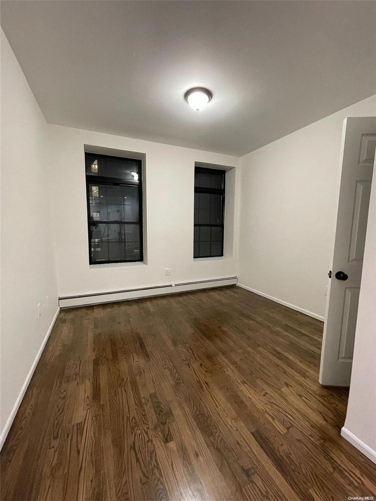2049 2nd Avenue Manhattan, NY 10029 - Photo 14 of 18 an empty room with wooden floor and windows